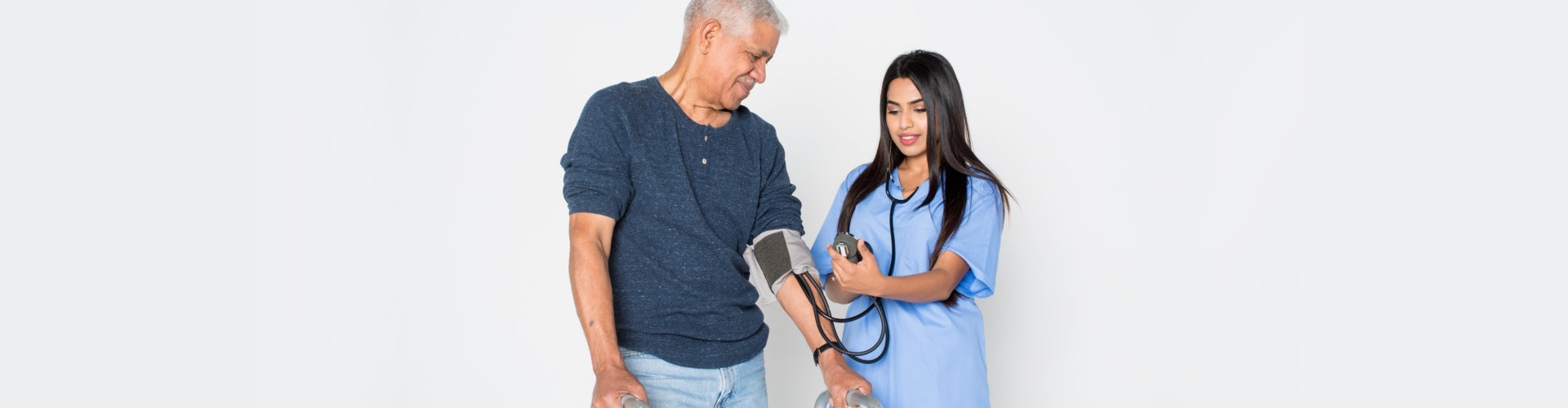 caregiver checking the blood pressure of her patient